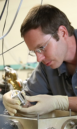 Research Assistant Professor Alexander Albrecht examines the world's first solid-state cryocooler – a device developed and built at The University of New Mexico.